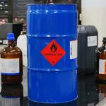 Blue chemical drum with flammable hazard label in a laboratory