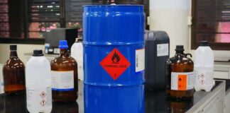 Blue chemical drum with flammable hazard label in a laboratory