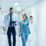 Mount Sinai Ends Youth Gender Treatments Doctors walking in a hospital corridor reviewing a tablet