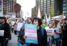 Reported Trans Killings Fall Sharply Crowd of protesters holding trans rights signs at a city rally