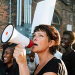 Woman with megaphone speaking at a street protest