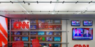 CNN newsroom set with red chairs and multiple TVs