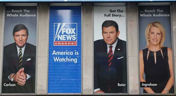 shutterstock_1474150775 Tucker Carlson and Bret Baier on large Fox News promotional posters