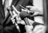 Microphones and recorders held toward a speaker