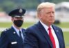 Donald Trump walking outdoors with an officer behind him; Chuck Howley not visible