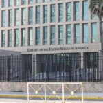 Embassy building behind tall black security fence