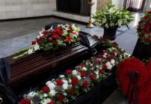Coffin with floral arrangements at a funeral service