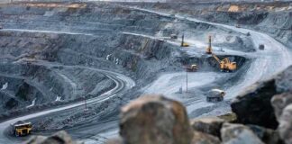 Open-pit mine with haul trucks and excavators on terraced roads