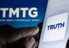 Smartphone showing Truth Social app icon beside TMTG logo on screen