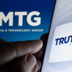 Trump Revives Feud With CNN Smartphone showing Truth Social app icon beside TMTG logo on screen