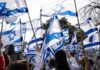 Crowd waving Israeli flags outdoors