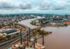 Aerial view of a river cutting through a modern city with bridges and ports