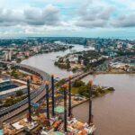 Aerial view of a river cutting through a modern city with bridges and ports