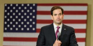 man in suit speaking into a microphone