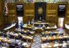 Legislative chamber with lawmakers debating a bill