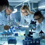 Scientists collaborating in a laboratory around a microscope