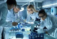 Scientists collaborating in a laboratory around a microscope