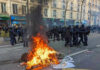 France Unrest: Real Crisis, Competing Explanations Fire burning on the street amid police presence.