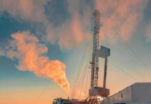 Oil drilling rig at sunset releasing steam