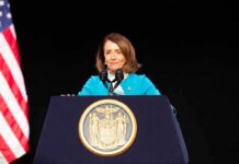 woman at podium with state seal speaking into microphones