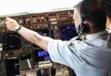 Pilot adjusting controls in an airplane cockpit