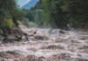 Nepal Flood Destroys 35 Homes and Bridges Flooded river gorge with fast muddy water and rocks