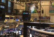 NYSE trading floor with monitors and tickers