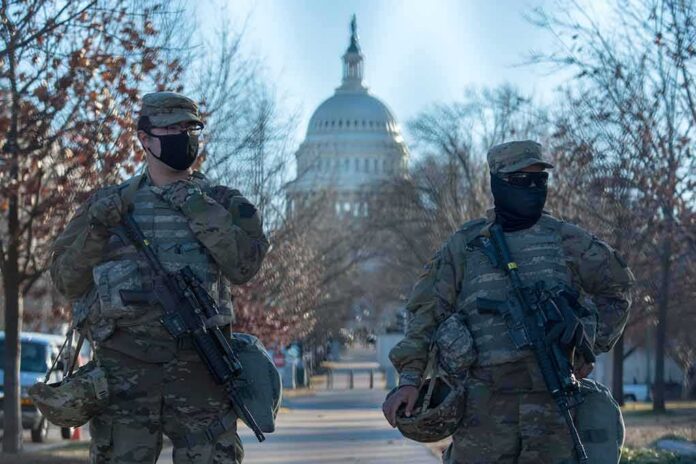 Two armed soldiers stand guard near a domed government building