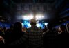 Racist Harassment Claims Rock Metal Scene Cowboy-hatted man watches a concert in a packed arena