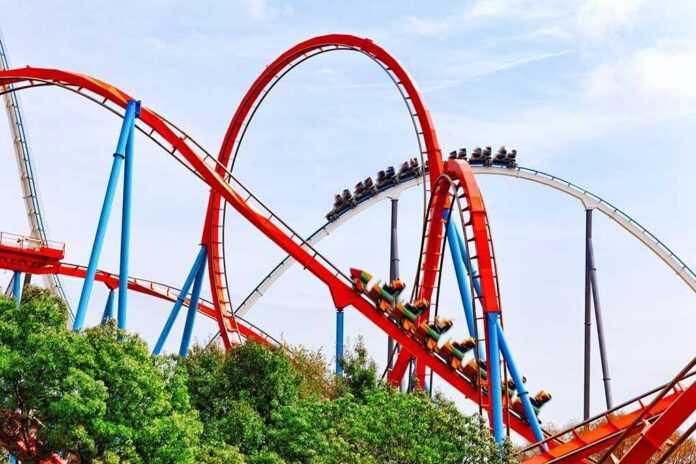 Colorful roller coaster with riders on a sunny day