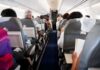 Airplane cabin with passengers seated in rows