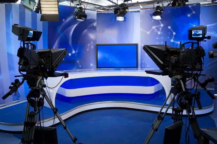 A television studio setup with cameras and a blue backdrop